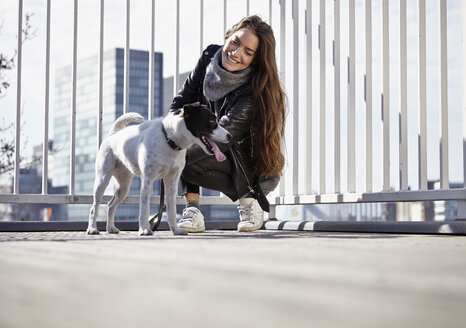 Deutschland, Düsseldorf, Junge Frau geht mit ihrem Hund spazieren - RHF000670