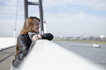 Deutschland, Düsseldorf, Junge Frau auf Brücke schaut in die Ferne - RHF000672