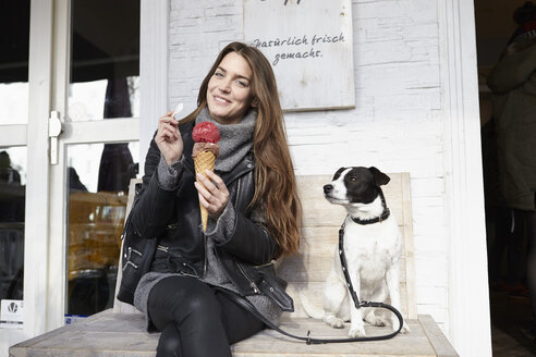 Deutschland, Düsseldorf, Junge Frau mit Hund isst Eiscreme - RHF000679