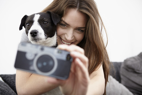 Junge Frau nimmt Selfie mit Hund, lizenzfreies Stockfoto