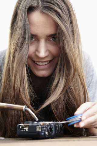 Junge Frau repariert Kamera, lizenzfreies Stockfoto