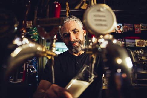 Mann zapft Bier in einem irischen Pub - MBEF001393
