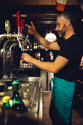 Mann zapft Bier in einem irischen Pub - MBEF001382