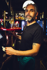 Porträt eines Kellners mit Tablett in einem irischen Pub - MBEF001396