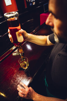 Kellner schenkt Whiskey in einem irischen Pub aus - MBEF001397