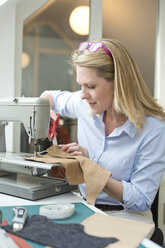 Woman with sewing machine tailoring - MAEF010148