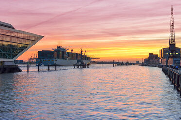 Deutschland, Hamburg, Containerschiff und Dockland-Gebäude bei Sonnenuntergang - RJF000415