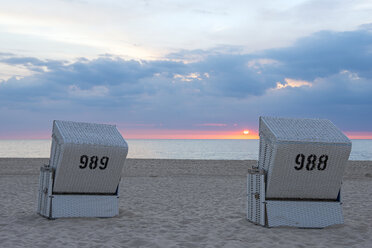 Deutschland, Schleswig-Holstein, Sylt, Westerland, Strandkörbe mit Kapuze am Strand bei Sonnenuntergang - KEBF000113