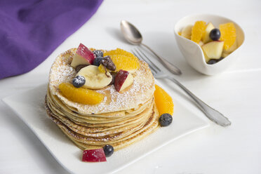 Stack of mini pancakes filled with chocolate cream and sliced fruits - YFF000350
