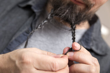 Man braiding his beard - MIDF000222