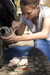 Woman repairing motor scooter - MIDF000250