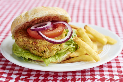 Veggi-Burger, Brokkoli, Karotten, Kichererbsen, Zwiebeln, serviert mit Pommes frites und Ketchup, lizenzfreies Stockfoto