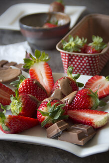 Teller mit in Scheiben geschnittenen und mit Schokolade überzogenen Erdbeeren - YFF000354