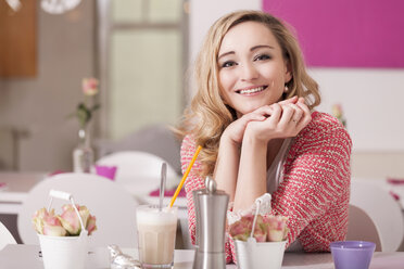 Porträt einer entspannten blonden Frau, die in einem Café mit Latte Macciato sitzt - JUNF000292
