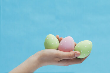 Woman's hand holding three coloured Easter eggs - BZF000088