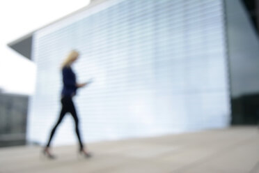 Geschäftsfrau im Gehen mit digitalem Tablet - BFRF001038