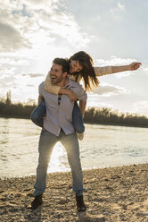 Happy young couple having fun at the riverside - UUF003760