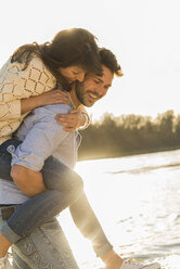 Happy young couple having fun at the riverside - UUF003764