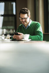 Mann macht eine Pause und benutzt ein Mobiltelefon - UUF003864