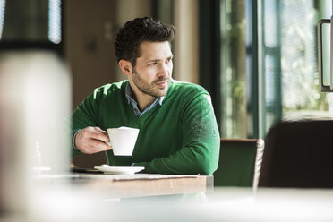 Man drinking coffee, looking away - UUF003796