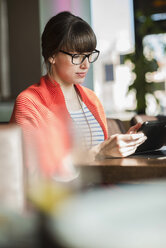 Junge Geschäftsfrau arbeitet in einem Café - UUF003798