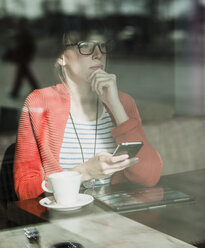 Junge Geschäftsfrau arbeitet in einem Café - UUF003803