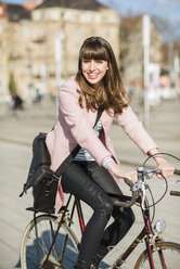 Junge Frau mit Fahrrad in der Stadt - UUF003866