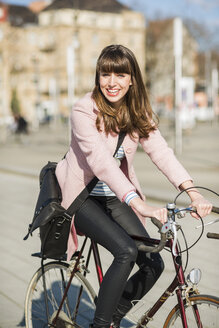 Junge Frau mit Fahrrad in der Stadt - UUF003866