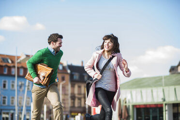 Happy couple running in the street - UUF003813