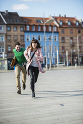 Happy couple running in the street - UUF003814