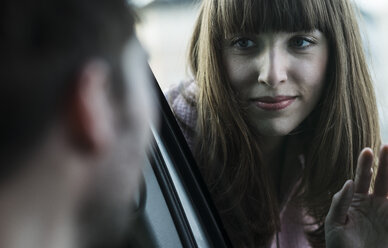 Couple saying farewell through windscreen - UUF003831