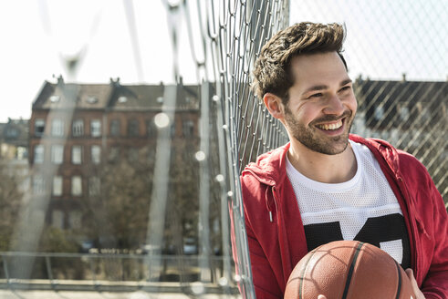 Junger Mann hält Korbball - UUF003835