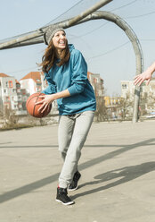 Junge Frau spielt Basketball - UUF003842