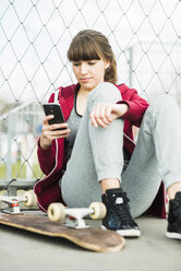 Junge Frau, die ein Smartphone benutzt - UUF003854
