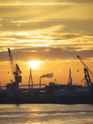 Deutschland, Hamburg, Silhouetten von Hafenkränen bei Sonnenuntergang, im Hintergrund die Köhlbrandbrücke - KRPF001407