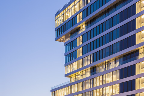 Deutschland, Renningen, Fassade mit beleuchteten Fenstern des Zentrums für Forschung und Vorausentwicklung, lizenzfreies Stockfoto