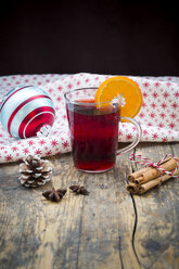 Glass of mulled wine, christmas bauble, cloth, cinnamon sticks and cinnamon stars - LVF003119