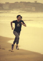 Spain, Gijon, Woman jogging at the beach - MGOF000187