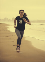 Spanien, Gijon, Frau beim Joggen am Strand - MGOF000188