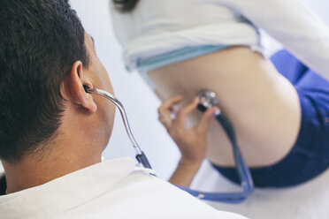 Doctor listening to patient's back with stethoscope - BZF000105