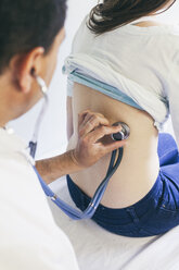 Doctor listening to patient's back with stethoscope - BZF000106