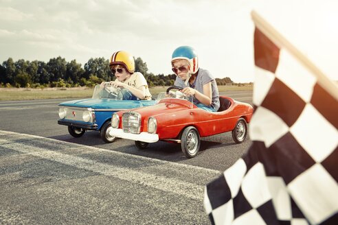 Two boys in pedal cars crossing finishing line on race track - EDF000159