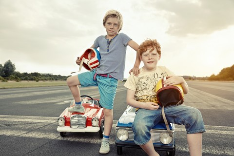 Two boys with pedal cars on race track stock photo
