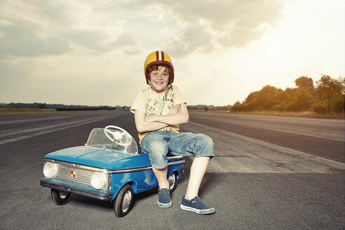 Lächelnder Junge mit Tretauto auf der Rennstrecke - EDF000168