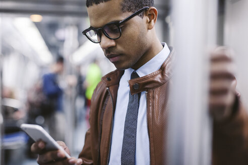 Businessman with smartphone on the subway train - EBSF000486