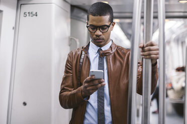 Businessman with smartphone on the subway train - EBSF000487