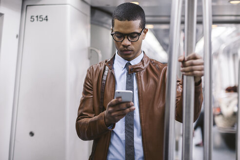 Geschäftsmann mit Smartphone in der U-Bahn - EBSF000487