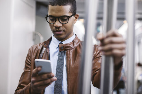Geschäftsmann mit Smartphone in der U-Bahn - EBSF000488
