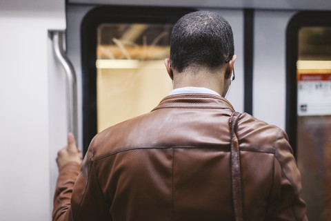 Rückenansicht eines Mannes in der U-Bahn, lizenzfreies Stockfoto