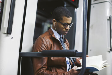 Businessman reading book on the subway train - EBSF000503